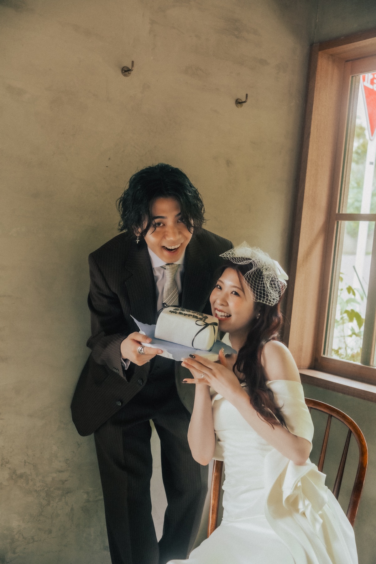 銚子スタジオでウェディングケーキを手に笑うふたりの前撮り写真