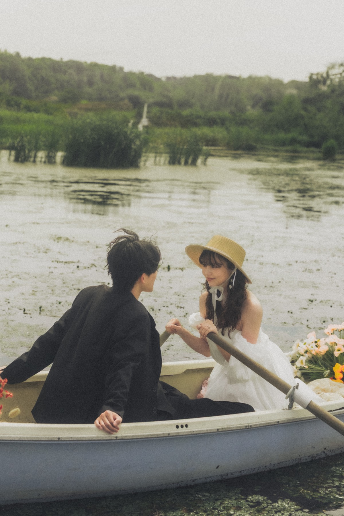 花で彩った白いボートで向き合うふたりのウェディングフォト